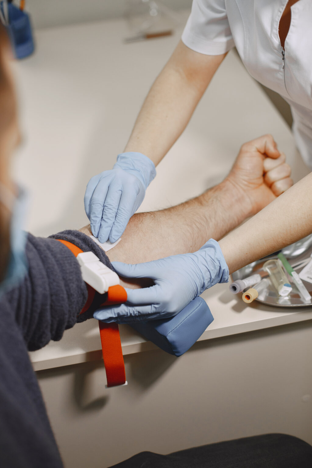 Nurse taking blood sample from patient at the doctors office